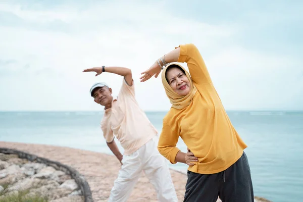 スポーティな女性と男性のトレーニングと一緒にビーチの屋外スポーツ — ストック写真