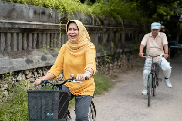 Szczęśliwy senior muzułmańskiej parze razem ćwiczenia jazdy na rowerze — Zdjęcie stockowe