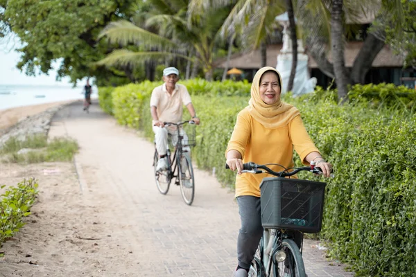 Glückliches muslimisches Senioren-Paar beim gemeinsamen Fahrradfahren — Stockfoto