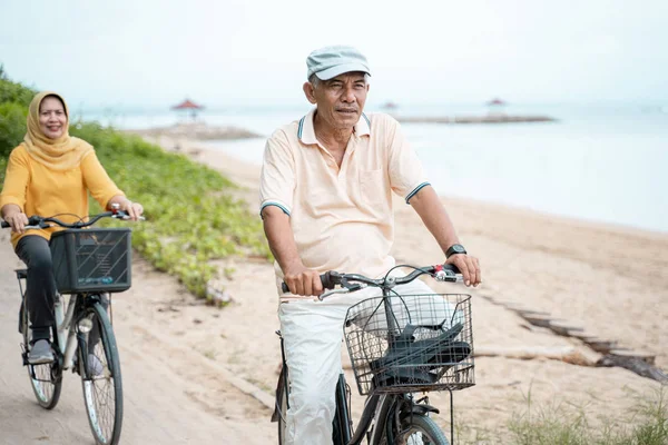 Glückliches muslimisches Senioren-Paar beim gemeinsamen Fahrradfahren — Stockfoto