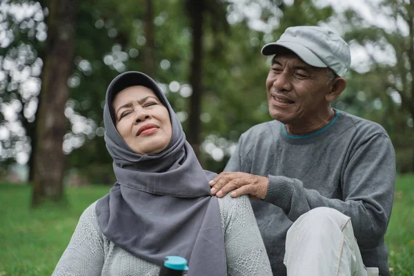 Senior pareja masculina dando algunos masaje en hombro y cuello a su esposa — Foto de Stock