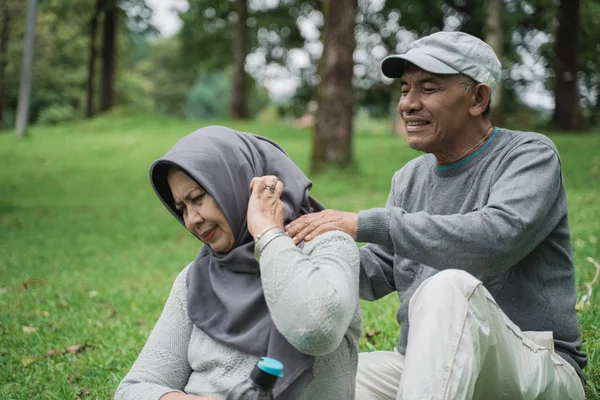 Senior mannelijke paar geven massage sommige op schouder en nek aan zijn vrouw — Stockfoto