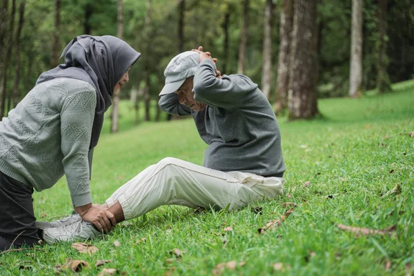 Gammal man gör sitta i parken med fru — Stockfoto