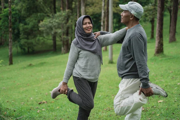 Pasangan muslim senior meregangkan kaki mereka — Stok Foto