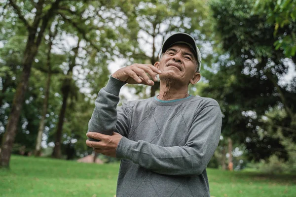 Viejo hombre sostenga su codo con dolor grave — Foto de Stock