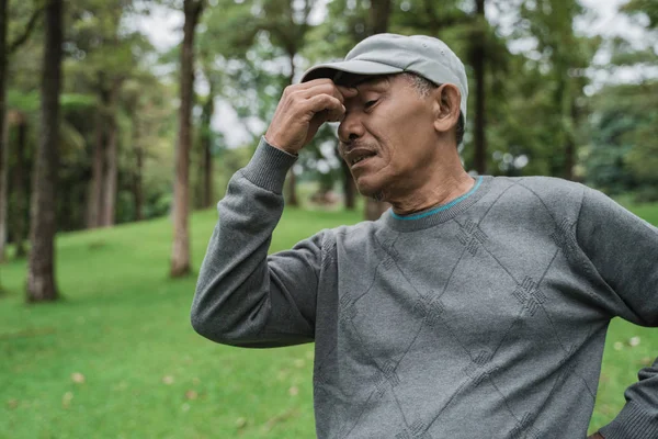 Senior asiático hombre teniendo dolor de cabeza — Foto de Stock