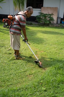 üst düzey Asya adam kendi ev Bahçe çim biçme 