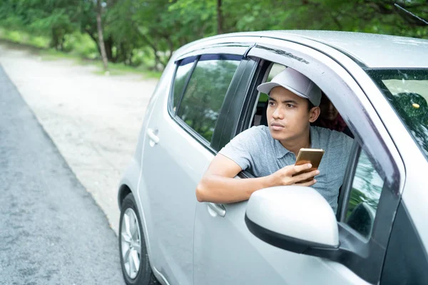 Mannelijke stuurprogramma zoeken locatie wanneer het zoeken van bestemming met smartphone — Stockfoto