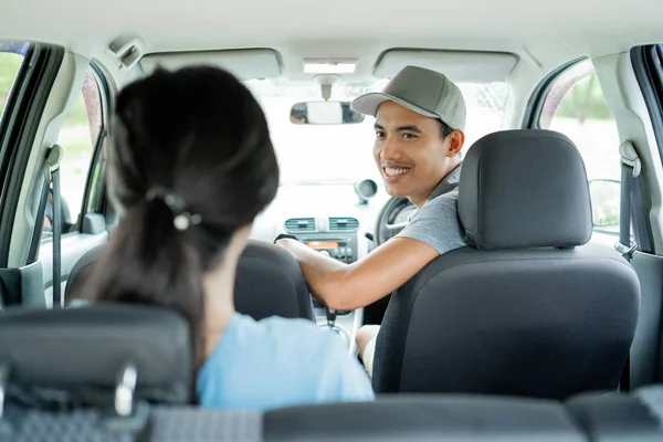 Aziatische jonge bestuurder vraagt aan zijn passagier zittend op de rugleuning — Stockfoto