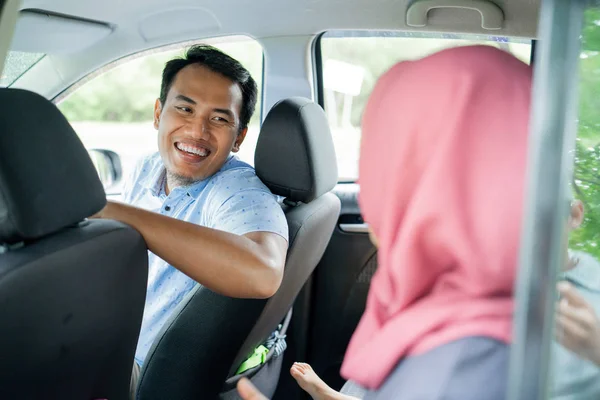 Homem motorista parece sorrir e feliz conversando com um passageiro hijab — Fotografia de Stock