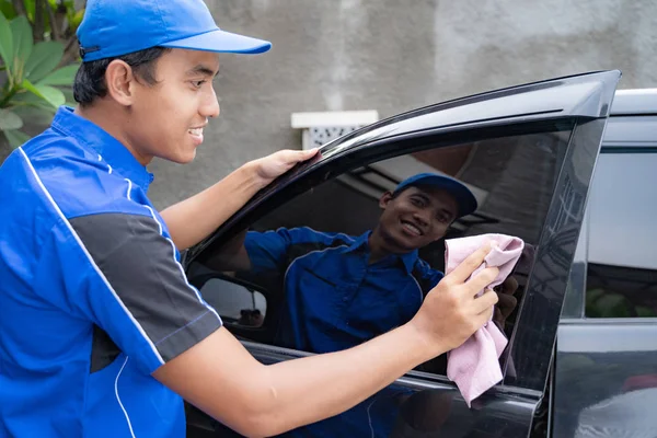 male car cleaning service worker washing black car