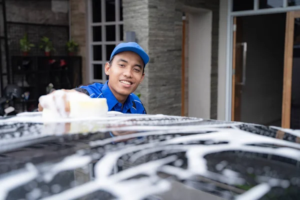 Άνδρας με στολή καθαρισμού του αυτοκινήτου τους πελάτες — Φωτογραφία Αρχείου