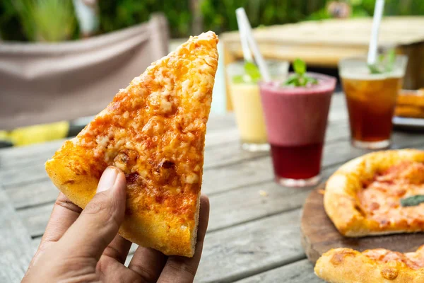 Retrato de la mano con una rebanada de pizza mirada una deliciosa con queso amarillo — Foto de Stock