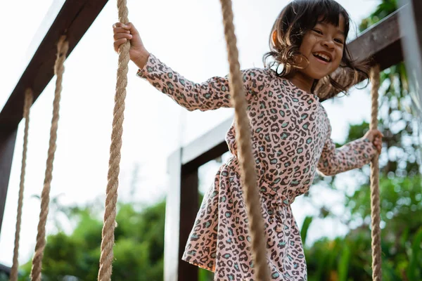 Detailní záběr z asijských malá holka smilling kdy držet lano hraje kladina — Stock fotografie