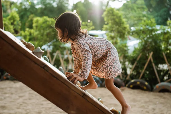 Une fille aime jouer sur la planche de bois grimper seul — Photo