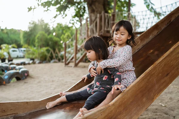 Duas meninas brincando slide juntos — Fotografia de Stock