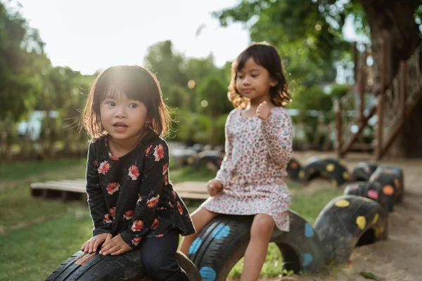 Дві маленькі дівчата насолоджуються грою на шинах грають в колі — стокове фото
