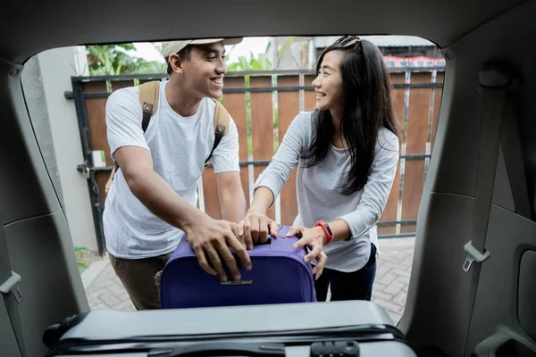 Pasangan menaruh koper ke dalam bagasi mobil — Stok Foto