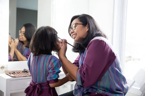 Mãe e filha aplicando compõem juntos — Fotografia de Stock