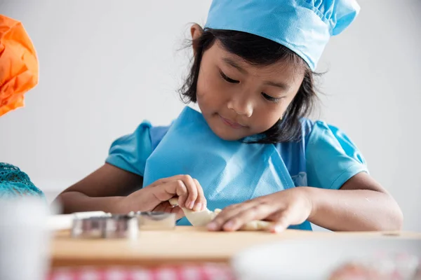 Menina com avental fazendo biscoitos — Fotografia de Stock