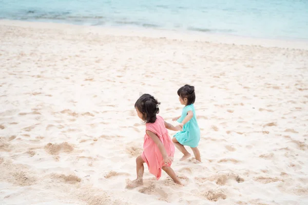 Діти ходять разом з рукою на узбережжі моря — стокове фото