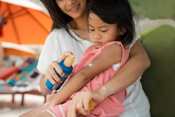 Dceru cítí pocit studené na kůži, když matka dát ochranný krém na ruce — Stock fotografie
