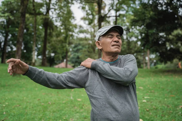 Senior mannelijke Aziatische na pijnlijke schouder en pijn op zijn gezamenlijke — Stockfoto