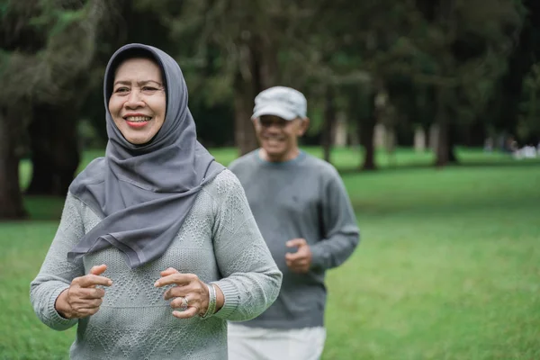 Pasangan yang berolahraga dengan berlari di taman — Stok Foto
