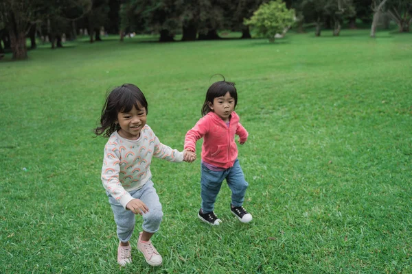 Malé děti s oblibou spouštějí v parku — Stock fotografie