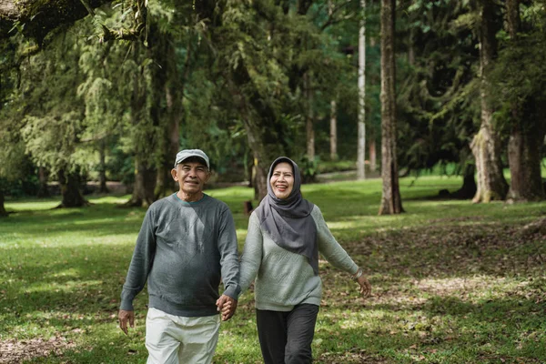 Musulmán pareja de ancianos caminando en el jardín juntos — Foto de Stock