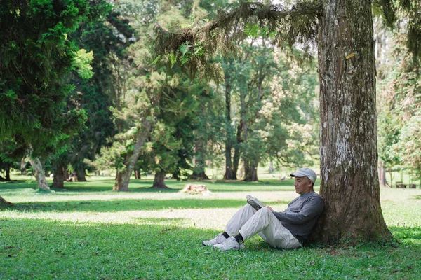 senior asian old man reading a book outdoor