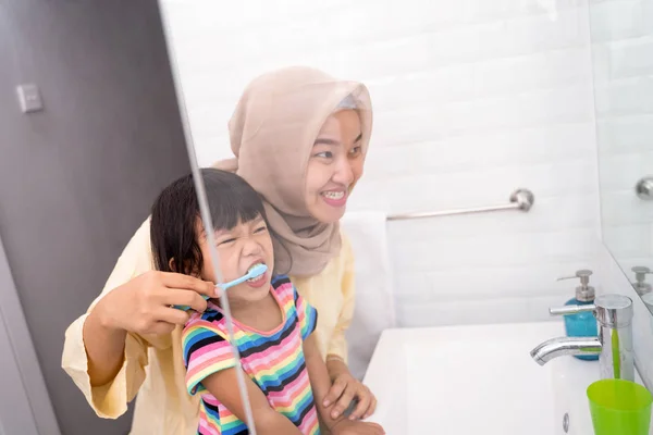 Мама чистит своим детям зубы — стоковое фото