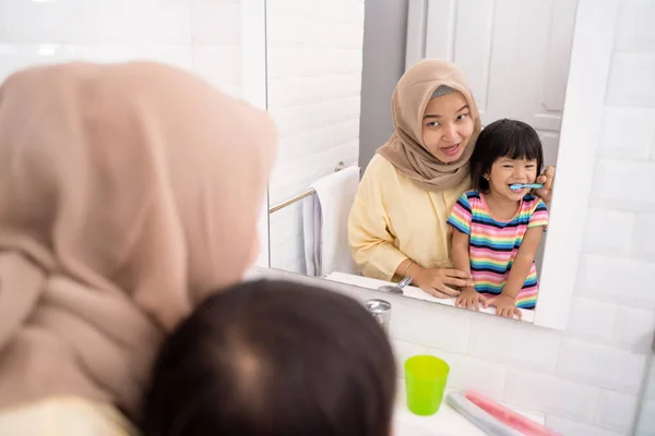 Moeder en haar dochter tandenpoetsen — Stockfoto