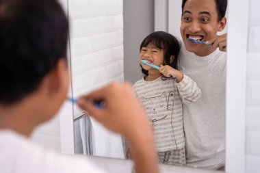 Baba ve kızı birlikte diş fırçalama