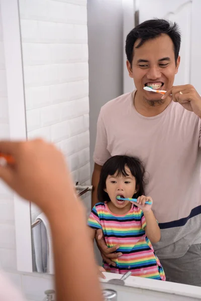 Papá y la chica se cepillan los dientes juntos —  Fotos de Stock