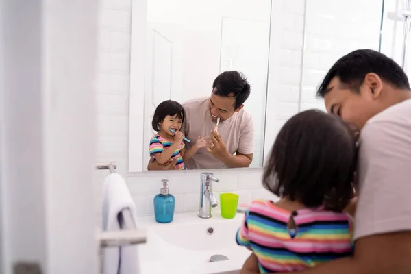 Padre e hija cepillando los dientes juntos — Foto de Stock