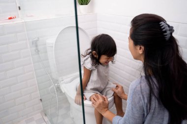 anne çocuğunu tuvaleti kullanmak için yardım