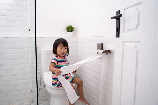 Малыш вытаскивает туалетную бумагу — стоковое фото