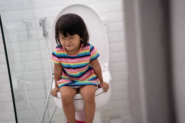 Lapsi kakkaa wc: hen — kuvapankkivalokuva