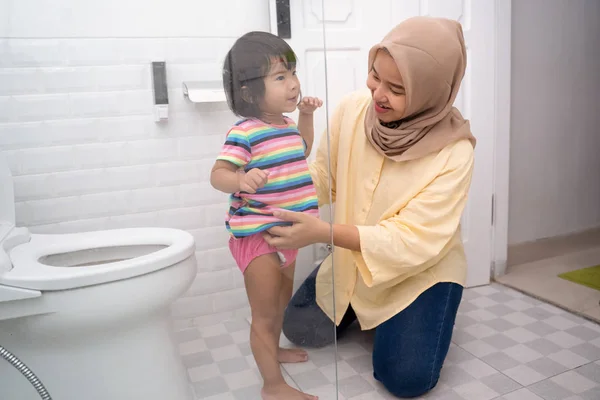Ibu muslim membantu anaknya menggunakan toilet — Stok Foto
