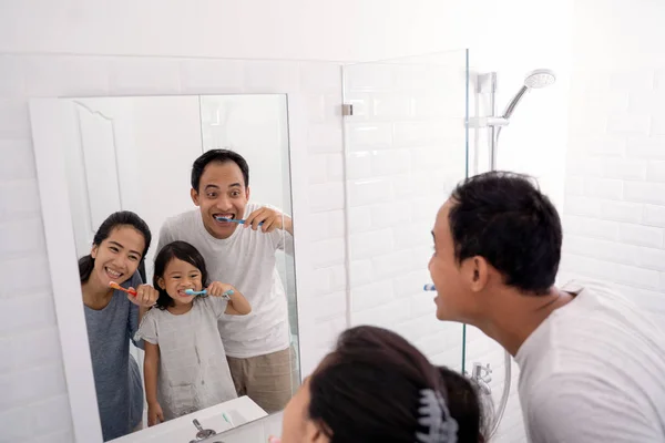 Счастливая азиатская семья чистить зубы вместе — стоковое фото