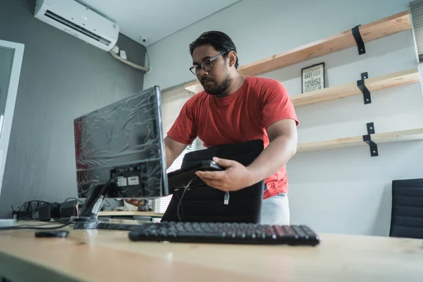 portrait of asian young man fix a problem with keyboard of personal computer