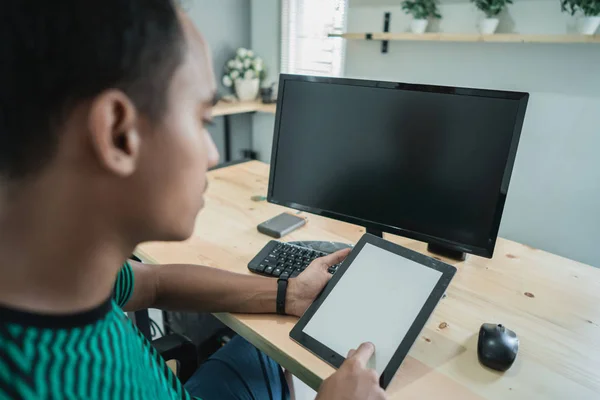 多くのモニターのコンピューターの前に座って彼女のビジネスのようなものを処理するタブレットを保持している青年実業家の肖像画 — ストック写真