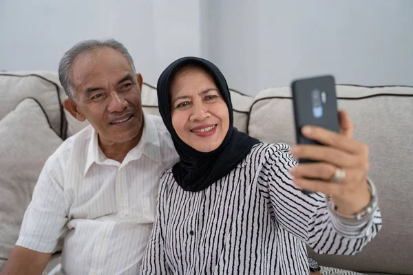 Pasangan matang mengambil selfie menggunakan smartphone — Stok Foto