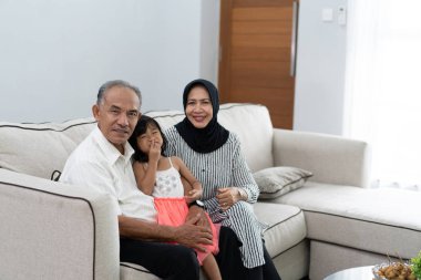 kameraya bakarak onların torunu ile mutlu büyükbaba veya büyükanne 