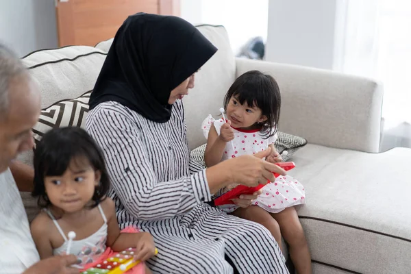 Nenek Muslim Asia menjelaskan bagaimana memainkan instrumen xilofon kepada cucunya — Stok Foto