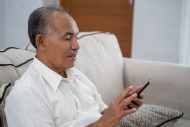 Yaşlı adam akıllı telefon evde kullanma