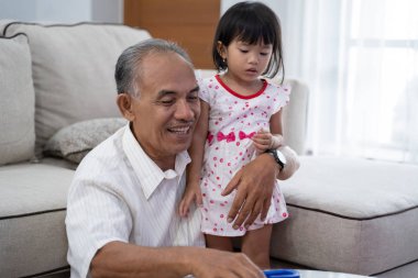 Büyükbaba ile evde oynayan çocuk 