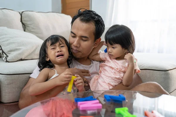 Padre rompiendo dos niñas peleando por coloridos juguetes de texto del alfabeto —  Fotos de Stock