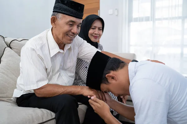 Man kneeling and kiss his parents hand asking for forgivness — Stock Photo, Image